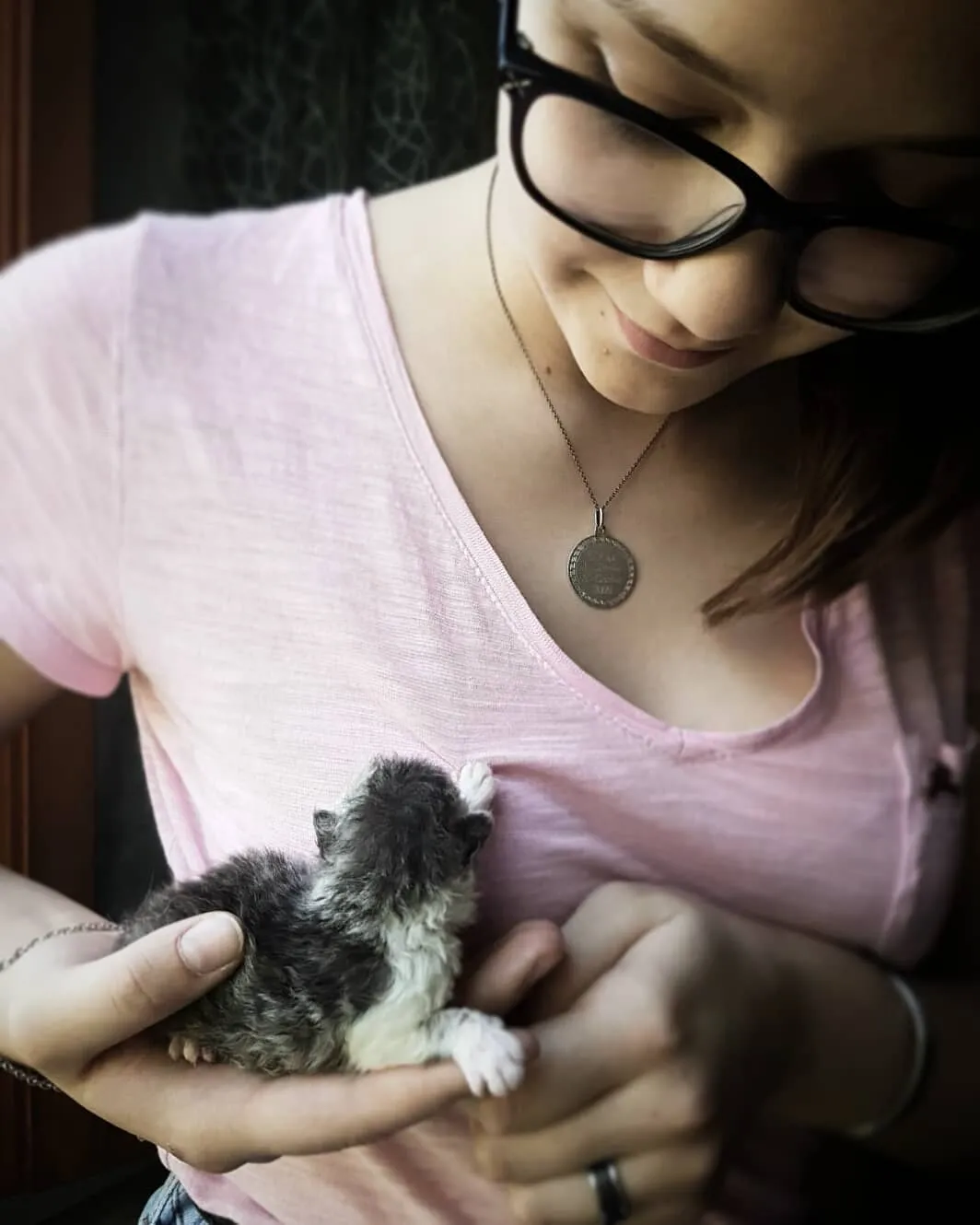 Alt Text: Un gatto Selkirk Rex cucciolo insieme alla sua famiglia umana, simbolo di un'adozione  di un gatto di razza felice.